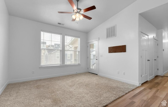unfurnished room with vaulted ceiling, ceiling fan, baseboards, and light wood-type flooring