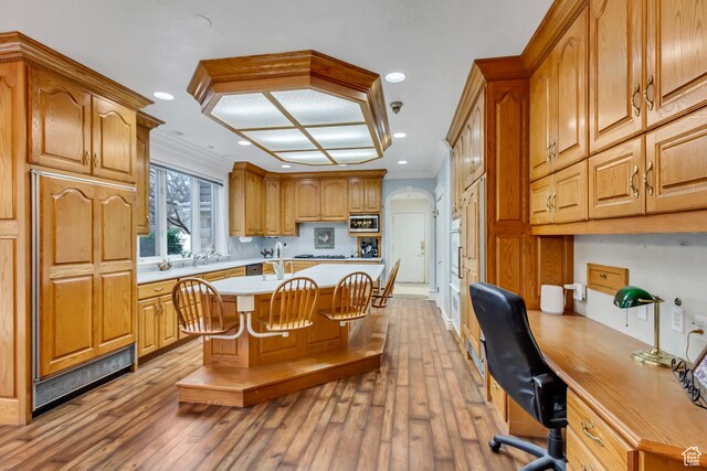 542 E 10000 S, Salem, UT 84653 - kitchen featuring light countertops, hardwood / wood-style flooring, stainless steel microwave, crown molding, and a center island with sink
