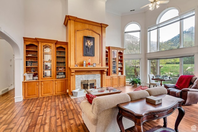 542 E 10000 S, Salem, UT 84653 - living area with a high ceiling, a fireplace, arched walkways, a ceiling fan, and wood-type flooring