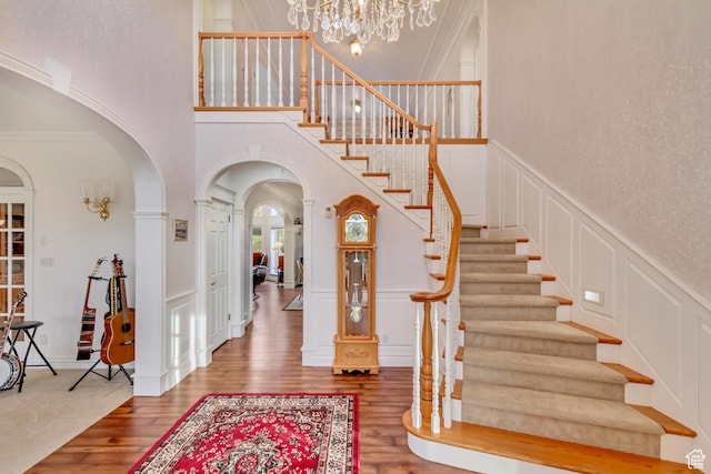 542 E 10000 S, Salem, UT 84653 - foyer entrance featuring a decorative wall, arched walkways, wood finished floors, a chandelier, and a high ceiling