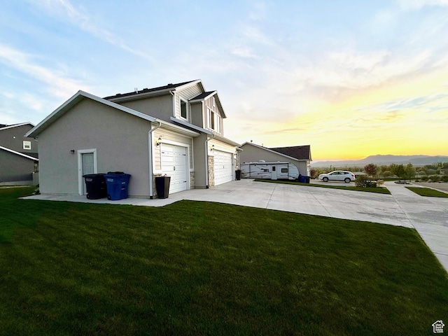 view of property exterior featuring concrete driveway, a lawn, and an attached garage