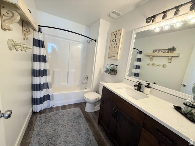 full bath with wood finished floors, vanity, toilet, shower / tub combo, and baseboards