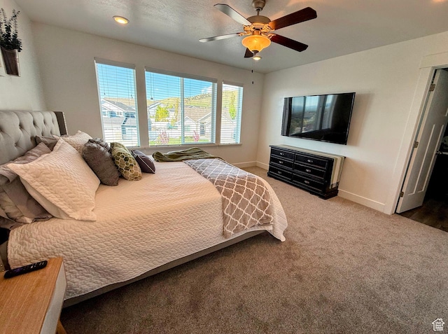 carpeted bedroom featuring baseboards and ceiling fan