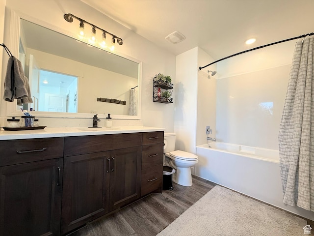 bathroom with wood finished floors, shower / bath combination with curtain, toilet, and vanity