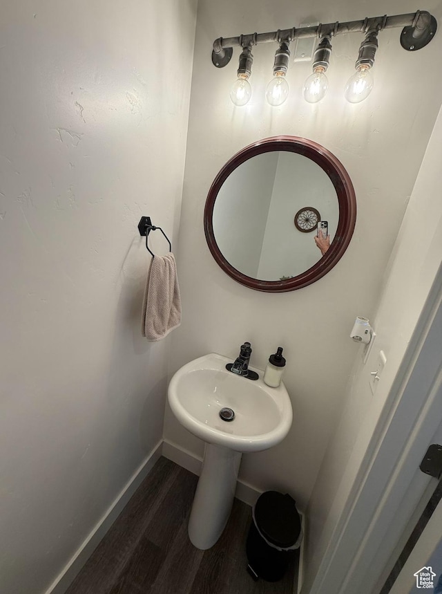 bathroom featuring wood finished floors, baseboards, and a sink
