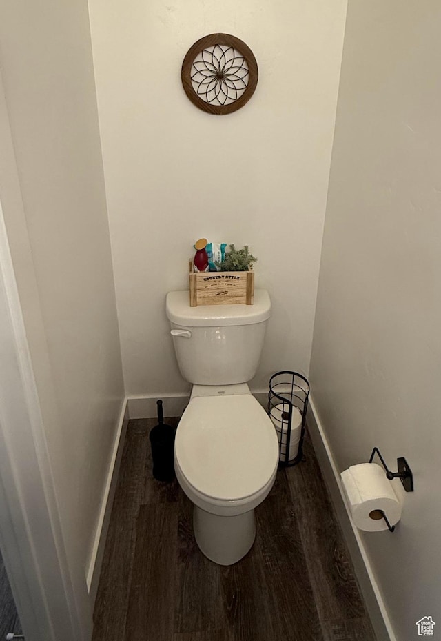 bathroom featuring wood finished floors, baseboards, and toilet