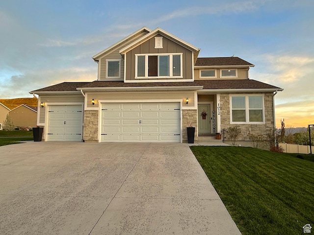 view of front of property featuring stone siding, concrete driveway, a front yard, and a garage