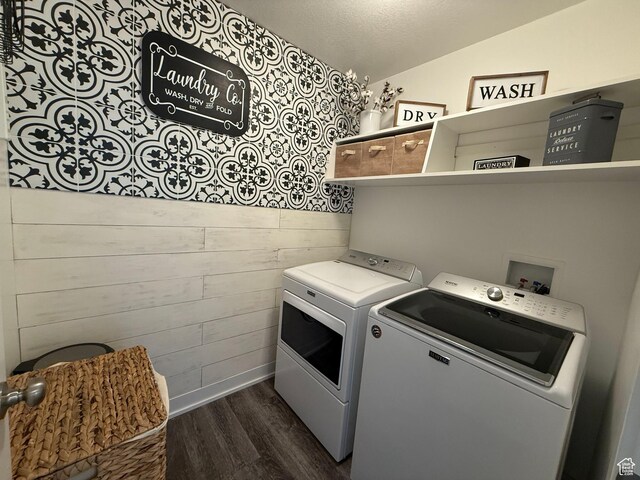 washroom featuring independent washer and dryer, dark wood-type flooring, wooden walls, and baseboards
