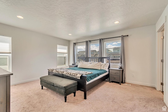 bedroom featuring light colored carpet, a textured ceiling, baseboards, and recessed lighting