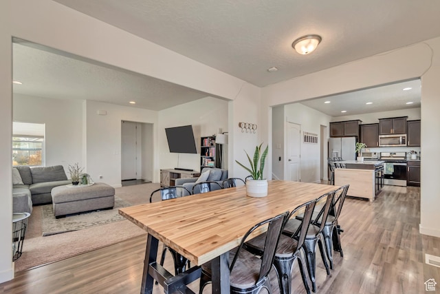 dining area featuring light wood-style flooring and recessed lighting