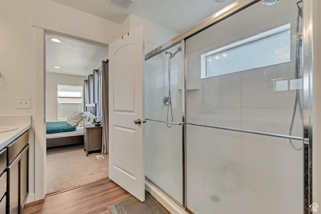 full bathroom with wood finished floors, a stall shower, connected bathroom, and vanity