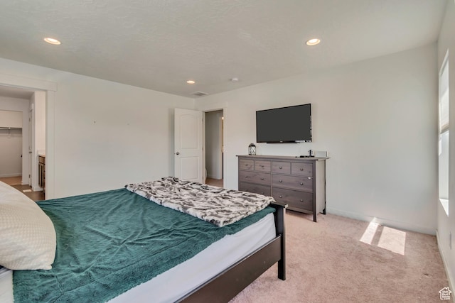bedroom with recessed lighting, light carpet, and baseboards