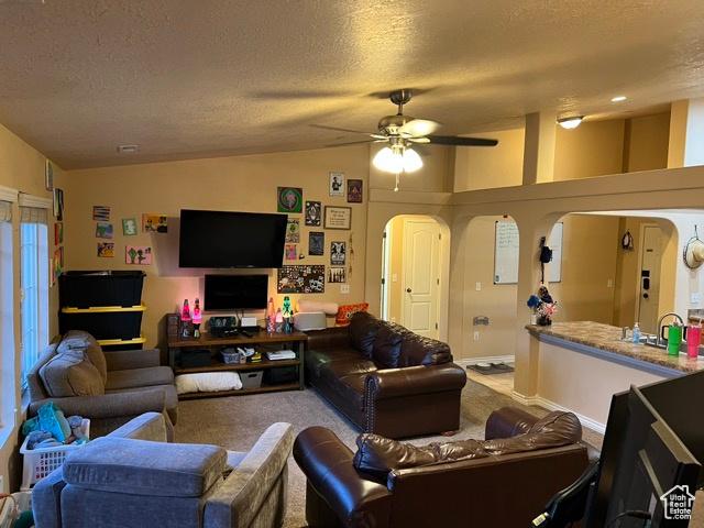 1195 W Dallin Dr N Unit R301, Pleasant Grove, UT 84062 - living room featuring arched walkways, lofted ceiling, carpet, a textured ceiling, and ceiling fan