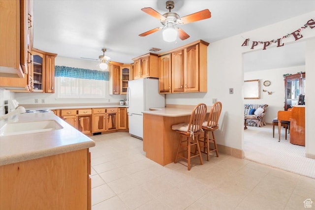 377 N 300 E, Nephi, UT 84648 - kitchen featuring freestanding refrigerator, a ceiling fan, a breakfast bar area, and glass insert cabinets