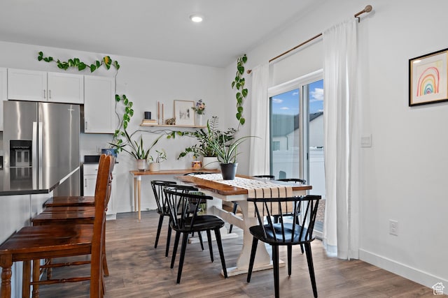 dining room featuring wood finished floors, recessed lighting, baseboards, and stairway