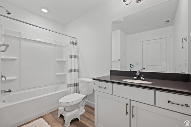 full bathroom featuring wood finished floors, toilet, vanity, shower / tub combo, and baseboards