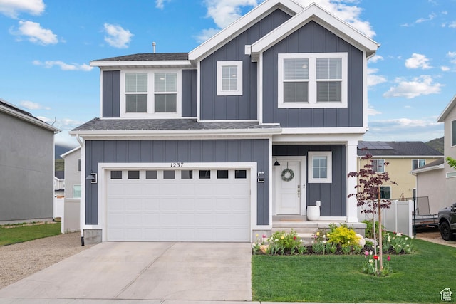 view of front of house with board and batten siding, concrete driveway, a front yard, and a garage