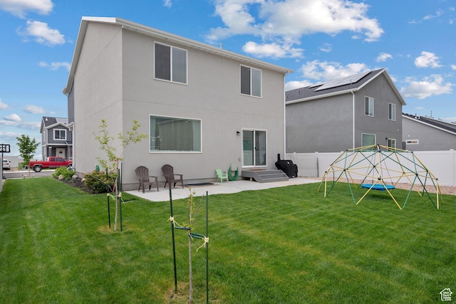 back of house featuring a patio, stucco siding, and a playground