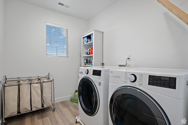 laundry area with independent washer and dryer, wood finished floors, and baseboards