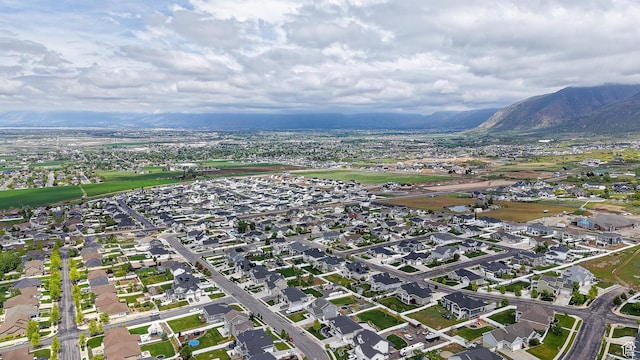 aerial view of property and surrounding area featuring a mountain backdrop and nearby suburban area
