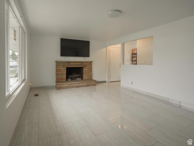 unfurnished living room with a fireplace and baseboards