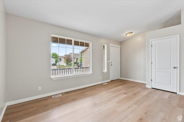 spare room featuring light wood-style floors and baseboards