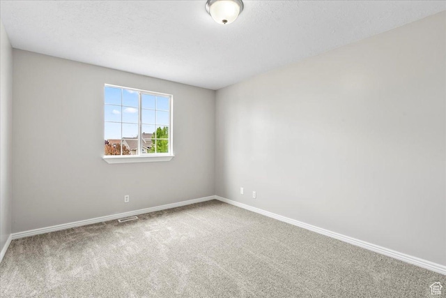 empty room featuring carpet flooring and baseboards