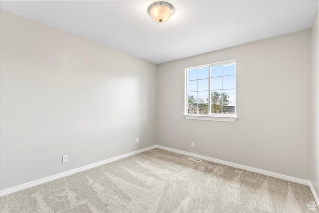 spare room featuring baseboards and carpet flooring