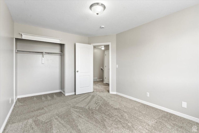 unfurnished bedroom featuring carpet, baseboards, and a closet