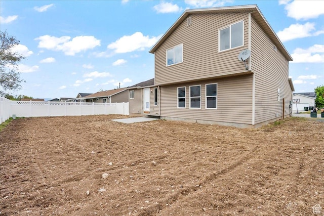 rear view of house featuring a patio area and fence