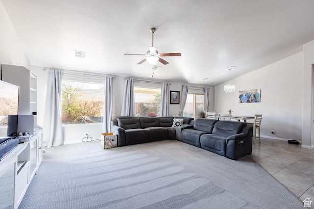living room with ceiling fan, vaulted ceiling, a chandelier, baseboards, and light tile patterned flooring