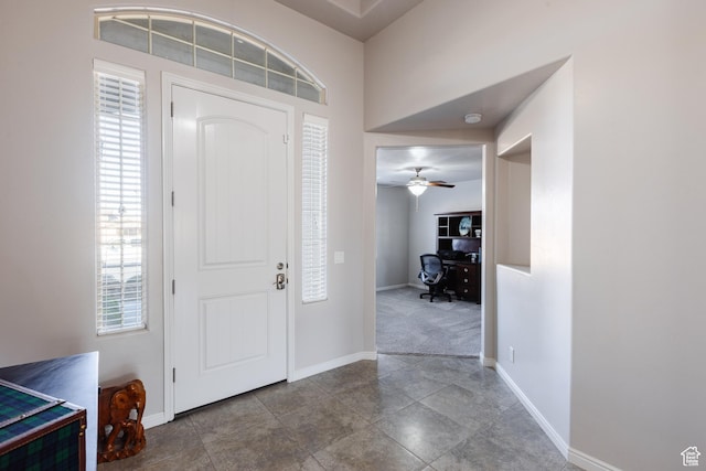 entryway with baseboards and a ceiling fan