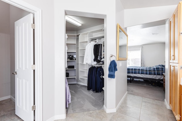 walk in closet featuring light carpet and light tile patterned floors