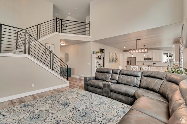 5402 N Meadow Lark Ln, Lehi, UT 84043 - living area with light wood-type flooring, stairs, baseboards, a towering ceiling, and recessed lighting