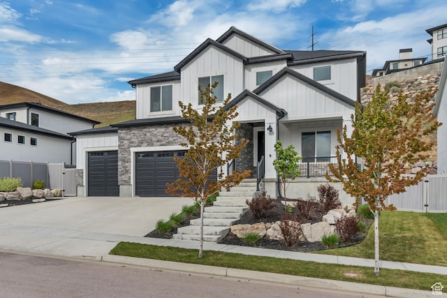 5402 N Meadow Lark Ln, Lehi, UT 84043 - view of front facade with board and batten siding, fence, driveway, an attached garage, and stone siding