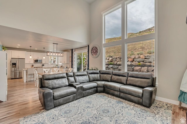 5402 N Meadow Lark Ln, Lehi, UT 84043 - living area with light wood-style floors, a high ceiling, baseboards, and recessed lighting