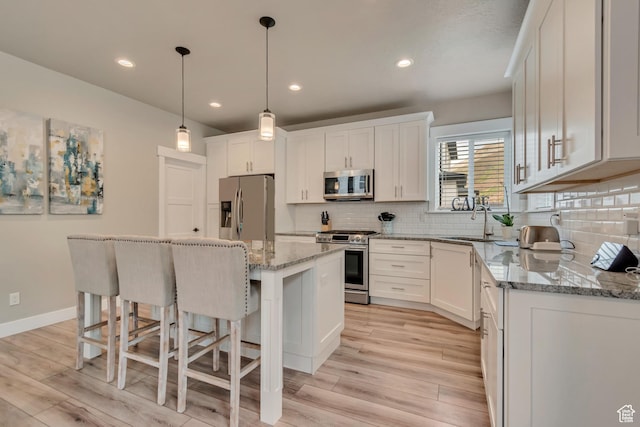 5402 N Meadow Lark Ln, Lehi, UT 84043 - kitchen featuring stainless steel appliances, light wood-style floors, a kitchen bar, white cabinetry, and recessed lighting