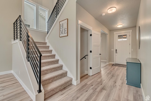 5402 N Meadow Lark Ln, Lehi, UT 84043 - entrance foyer with light wood-style flooring, baseboards, stairs, and a textured ceiling