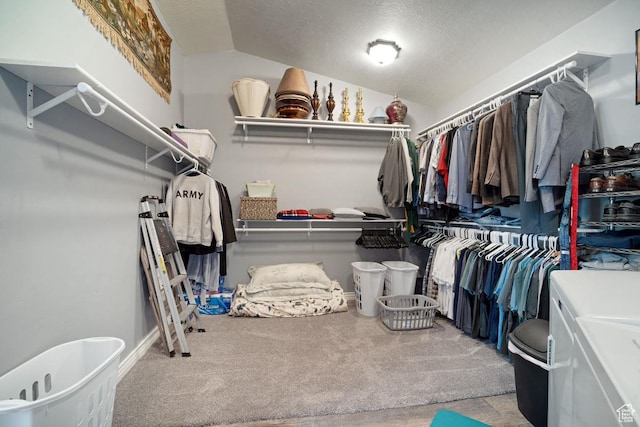 walk in closet with carpet, vaulted ceiling, and separate washer and dryer