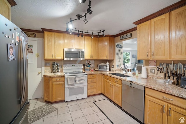 kitchen with appliances with stainless steel finishes, a sink, light tile patterned floors, light stone countertops, and light brown cabinets
