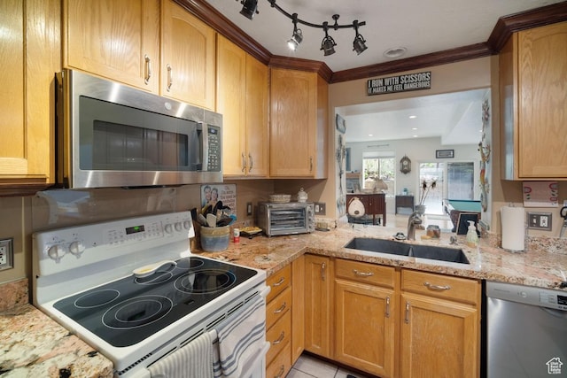 kitchen featuring stainless steel appliances, a sink, light stone countertops, and crown molding