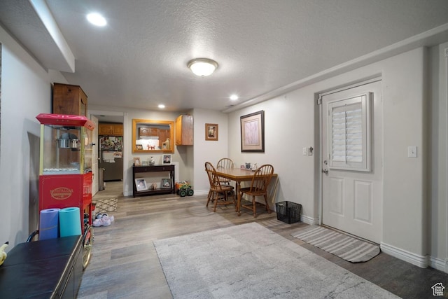 foyer with wood finished floors, baseboards, recessed lighting, and a textured ceiling