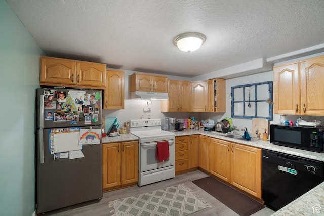 kitchen featuring black appliances, under cabinet range hood, a sink, a textured ceiling, and light wood finished floors