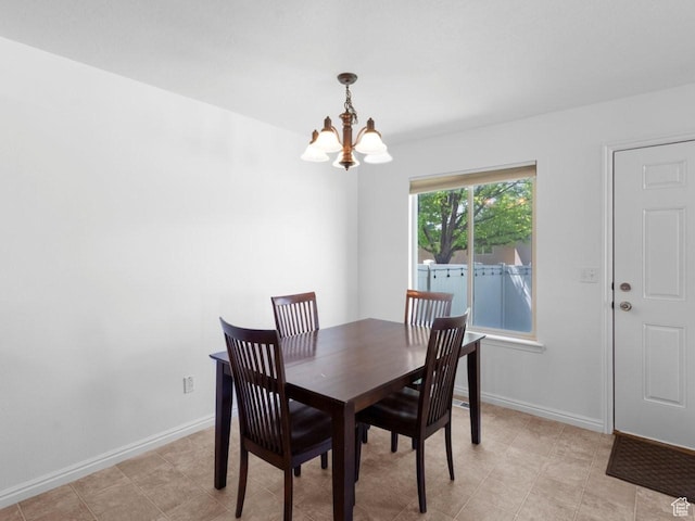 dining area featuring a chandelier and baseboards