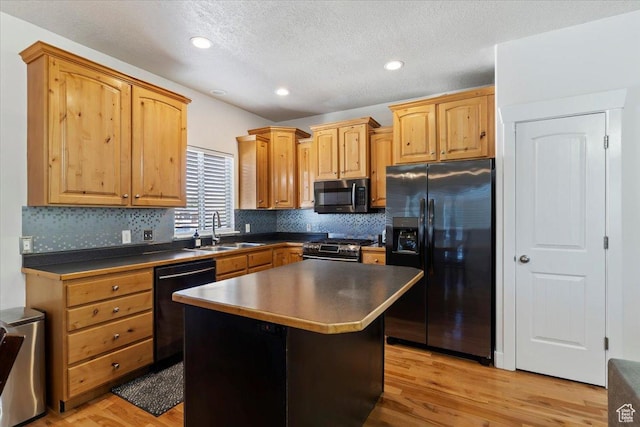 2099 W 700 S, Syracuse, UT 84075 - kitchen with black appliances, a sink, dark countertops, decorative backsplash, and a center island