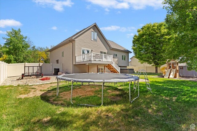 2099 W 700 S, Syracuse, UT 84075 - rear view of house featuring a trampoline, a playground, a wooden deck, and stairs