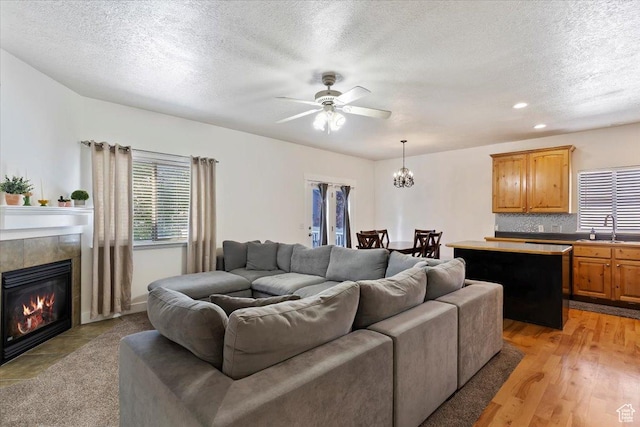 2099 W 700 S, Syracuse, UT 84075 - living room with ceiling fan, a textured ceiling, a tiled fireplace, a chandelier, and recessed lighting