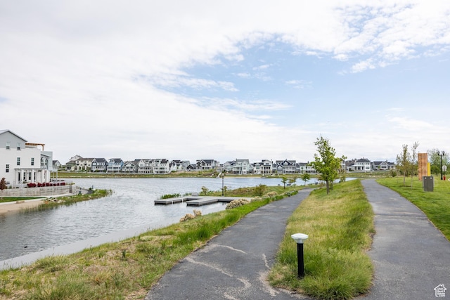 water view featuring nearby suburban area and a boat dock