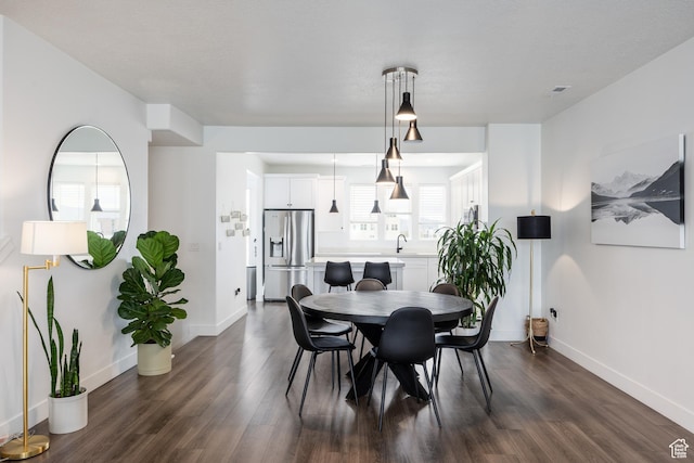 dining room with dark wood-type flooring and baseboards
