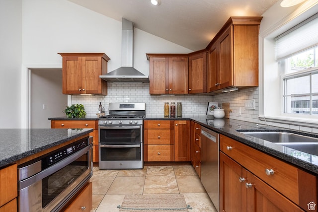 1845 E Princeton Ave, Salt Lake City, UT 84108 - kitchen with wall chimney range hood, stainless steel appliances, vaulted ceiling, brown cabinets, and backsplash